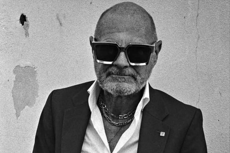 Detail from one of the images - a man wearing large square sunglasses and neck chains- from David Collyer's '50 PLUS...' photobook.